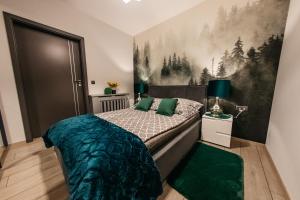 1 dormitorio con 1 cama y una pintura en la pared en Apartamenty Długa 7, en Racibórz