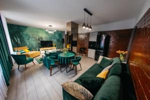- un salon avec un canapé vert et une table dans l'établissement Apartamenty Długa 7, à Racibórz