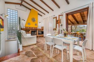 cocina y comedor con mesa blanca y sillas en Villa Miceli, en Scopello