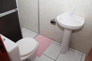 a bathroom with a toilet and a sink at Residencial Aracuã in Bombinhas +55 photos