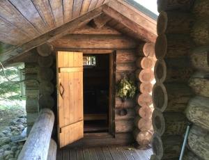 a log cabin with a door on the side of a building at Russet & Rowanberry - Russet Holiday House in Paide