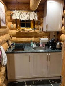 a kitchen with a sink in a log cabin at Russet & Rowanberry - Russet Holiday House in Paide