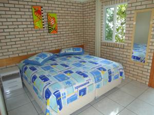a bedroom with a bed in a brick wall at Residencial Aracuã in Bombinhas