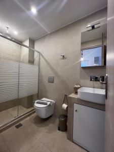 a bathroom with a toilet and a sink and a shower at "Calm Joy & J" - Infinity in Ermoupoli