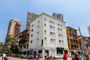 un bâtiment blanc dans une rue de la ville avec des bâtiments dans l'établissement Hotel New Imperial, à Mumbai