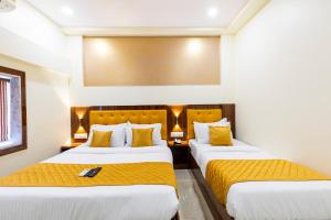 Habitación de hotel con 2 camas con sábanas amarillas en Hotel New Imperial, en Bombay