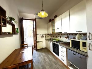 kuchnia z białymi szafkami i drewnianym stołem w obiekcie Appartamento Firenze Mayer we Florencji +24 zdjęcia