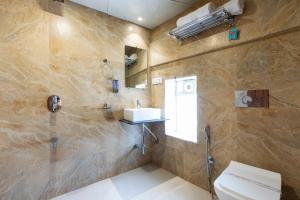 a bathroom with a shower and a sink and a toilet at Hotel New Imperial in Mumbai