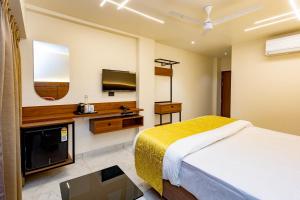 a hotel room with a bed and a flat screen tv at Uphills boutique hotel in Kallar Vattiyar