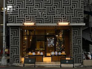 a store front with a black and white pattern on a building at Aroma Chew Hotel in Taichung