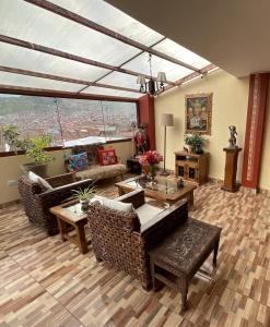 a living room with furniture and a large window at Hotel Andean Host Inn in Cusco