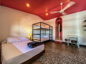 1 dormitorio con 2 literas y techo rojo en Fardo Hotel Boutique Ibague - Recepción Digital 24H, en Ibagué