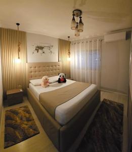 two stuffed animals sitting on a bed in a bedroom at Bala Apartment in Shkodër