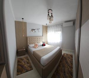 a bedroom with a bed with a teddy bear on it at Bala Apartment in Shkodër