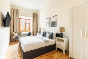 a bedroom with a king sized bed and a desk at Rynek 10 Apartments in Lublin