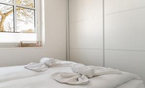 a white bedroom with towels on a bed at Abendmond in Zinnowitz +10 photos