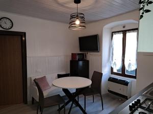 a small room with a table and chairs and a clock at Da Daniela in Storo