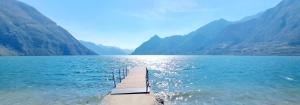 a dock in the middle of a lake with mountains at Da Daniela in Storo