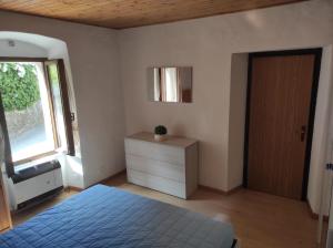 a bedroom with a bed and a dresser and a window at Da Daniela in Storo