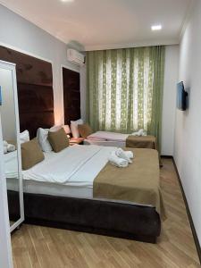 a bedroom with two beds with towels on them at Viva Hotel Gabala with Sauna, Pool, Waterfall and Fireplace in Gabala