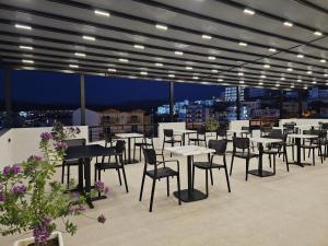 ein Restaurant mit Tischen und Stühlen auf dem Dach in der Unterkunft Monel Hotel in Ksamil