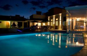 a swimming pool in front of a house at night at Solar del Pago in San Antonio de Areco