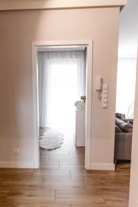 an open door to a living room with a couch at Apartament Rozmarynowa Residence 8 Opole in Opole