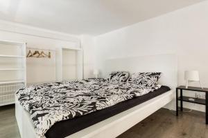 a white bedroom with a black and white bed at 57 Steps from the Basilica in Budapest