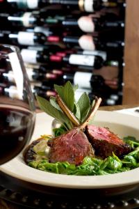 a plate of food next to a bottle of wine at The Rusty Parrot Lodge and Spa in Jackson