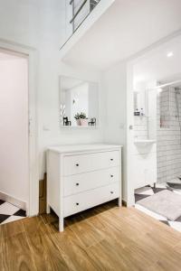 a white dresser in a white room with a mirror at 57 Steps from the Basilica in Budapest