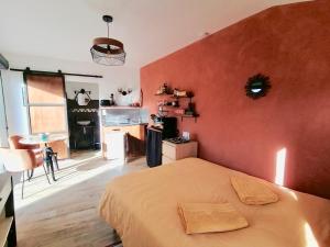 a bedroom with a bed and a red wall at Le cocon Cévenol in Anduze