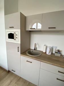 a white kitchen with a sink and a microwave at Golden Rush in Rīga
