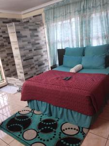 a bedroom with a bed with a red bedspread at comfort zone guest house in Zeerust