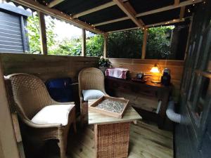 a porch with a table and chairs and a desk at "Tempat Senang" chalet on the beautiful Veluwe with airco sauna bbq jacuzzi beamer and dog in Putten