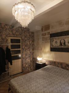 sypialnia z dużym łóżkiem i żyrandolem w obiekcie Maison intra muros, terrasses avec vue jaccuzzi et garage w Awinionie +20 zdjęć