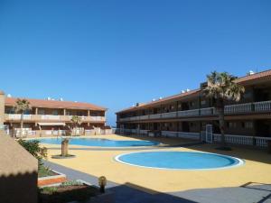 um resort com duas piscinas e palmeiras em Apartamento Dulce Vista em Poris de Abona