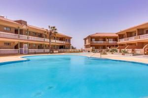 a large blue swimming pool in front of buildings at Apartamento Dulce Vista in Poris de Abona