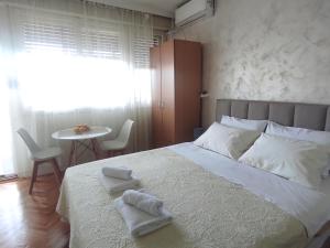 a bedroom with a bed with two towels on it at Apartment Clock Tower in Podgorica