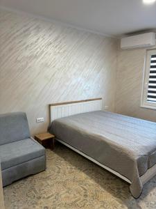 1 dormitorio con 1 cama y 1 sofá en КЪЩА ЗА ГОСТИ ПЕРЛА, en Belogradchik