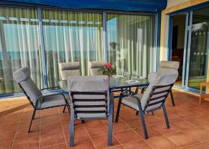 a glass table and chairs on a balcony at Villa Marina in Ayia Thekla with Heated Pool in Ayia Napa