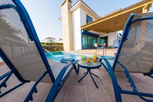 a patio with chairs and a swimming pool at Villa Marina in Ayia Thekla with Heated Pool in Ayia Napa