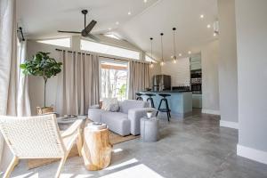 Nearly Oceanfront Blue 3 Bedroom Spacious Villa في بلايا فيناو: غرفة معيشة مع أريكة ومطبخ