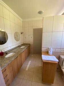 a bathroom with two sinks and two mirrors at Pousada Recanto Pomerano in Pomerode +51 photos
