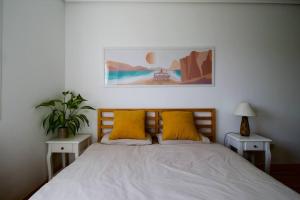 1 dormitorio con 1 cama con almohadas amarillas en Apartamento tranquilo en miengo, en Miengo