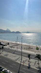 a beach with people on the sand and the water at Apartamento em copacabana VISTA MAR in Rio de Janeiro