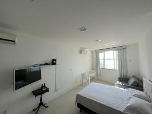 a bedroom with a bed and a flat screen tv at Apartamento em copacabana VISTA MAR in Rio de Janeiro