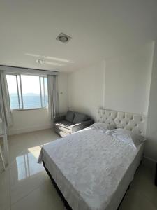 a white bedroom with a bed and a couch at Apartamento em copacabana VISTA MAR in Rio de Janeiro