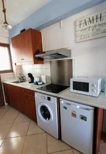 a kitchen with a washing machine and a microwave at Agapi Studio Acharavi à 50m de la mer, 400m du centre ville in Acharavi