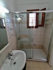 a bathroom with a shower and a sink and a tub at Agapi Studio Acharavi à 50m de la mer, 400m du centre ville in Acharavi