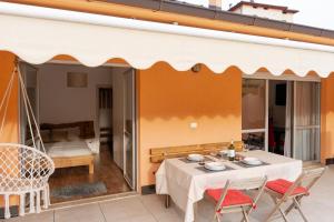 a patio with a table and chairs and a bed at Casa vacanze Filos in Pergine Valsugana